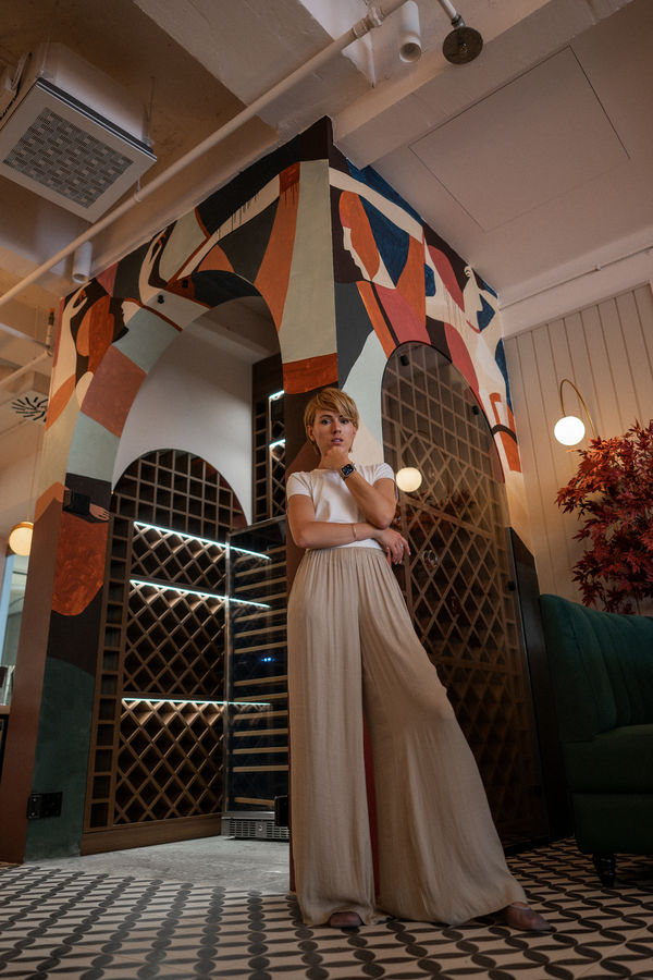 Al Bocconcino — Elena in front of painted wine cellar arch