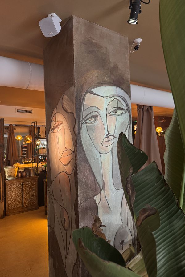 Como Yo — mural column with painted faces and tropical plants